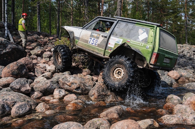 An action shot of the 2025 Ford Ranger driving through a muddy off-road trail, showcasing its ground clearance, suspension articulation, and overall ruggedness.