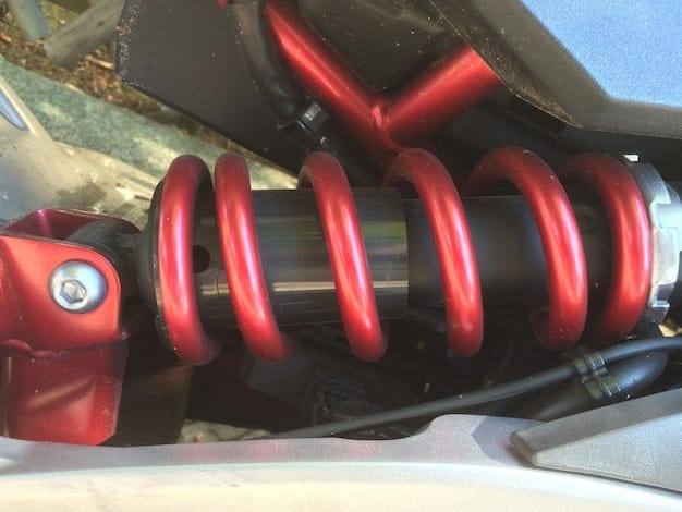 A close-up of the Honda Ridgeline's rear suspension, highlighting the independent rear suspension system which contributes to its smooth ride quality. The components are clean and modern, showcasing the engineering behind the unibody design.