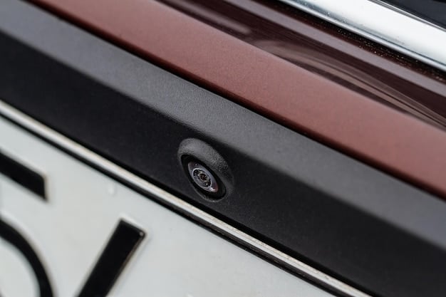 Close-up view of the 2025 Hyundai Santa Cruz's bed, showcasing its integrated tonneau cover, tie-down points, and under-bed storage compartment. The bed contains some camping gear, highlighting its utility for outdoor adventures.