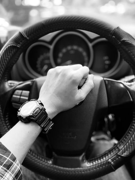 A driver is shown gripping the steering wheel of the 2025 Mazda MX-5 Miata, focusing on the driver's hands and the tactile feel of the leather-wrapped steering wheel. The image emphasizes the car's driver-centric design and the connection between the driver and the machine.