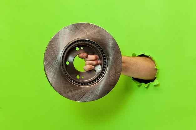 A mechanic holding up a worn-out brake pad next to a new brake pad, clearly illustrating the difference in thickness. The brake rotor and caliper are visible in the background, emphasizing the components involved in a brake job.