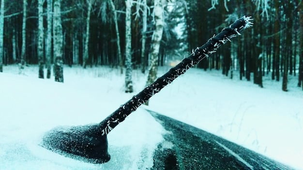 A car windshield with new, clean wiper blades clearing away falling snow, providing a clear view of the road ahead.