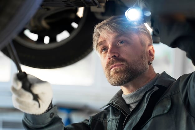 A mechanic inspecting brake pads on a vehicle, with tools and safety glasses visible. The focus is on the condition of the pads and the rotor.