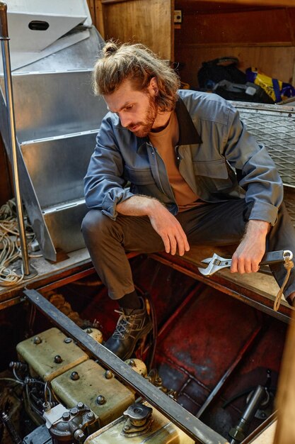 A DIY enthusiast is shown performing a radiator flush on their car in their garage. They are wearing safety glasses and gloves, and the scene is well-lit. Various tools and containers are neatly arranged around the vehicle.