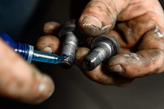 A close-up of a mechanic using a spark plug socket wrench to remove a spark plug from an engine. The engine bay is cluttered, but the focus is on the spark plug being removed.
