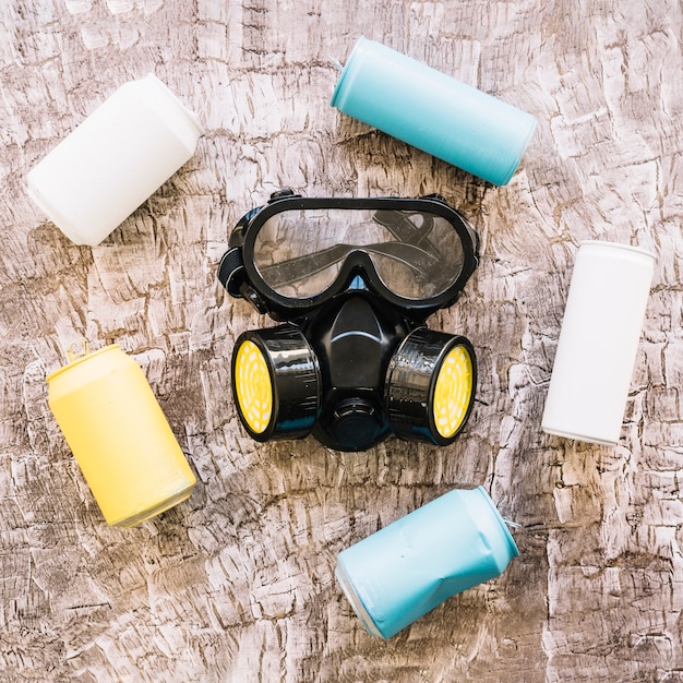 A collection of items needed for headlight restoration laid out on a table, including sandpaper of various grits, masking tape, headlight cleaner spray, UV protectant, and microfiber cloths.