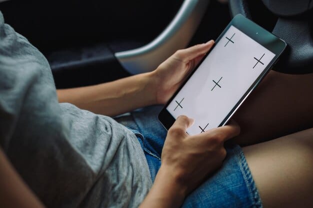 Close-up shot of a person's hand using a smartphone to browse a used car website, showing various listings with prices and vehicle details. Focus on the screen with a blurred background of a living room.