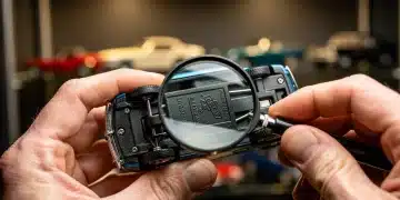 Collector examining vintage diecast model authenticity with magnifying glass