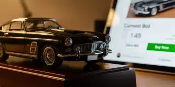Detailed vintage diecast model car on a stand with an online auction interface in the background.